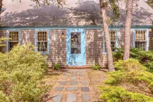 a house with a blue door and trees at Pretty on Prada in Edgartown