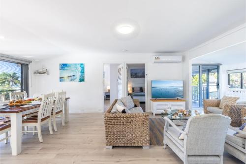 a living room with a table and a dining room at Blue Waters 7 Cook St - Dog Friendly and Water Views in Salamander Bay