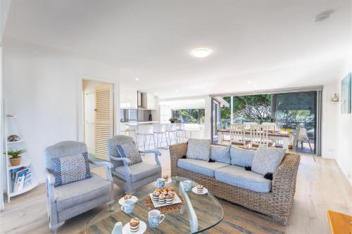 a living room with two couches and a table at Blue Waters 7 Cook St - Dog Friendly and Water Views in Salamander Bay
