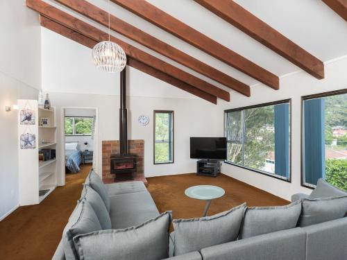 a living room with a couch and a tv at Central Spacious Family House - Paihia House in Paihia