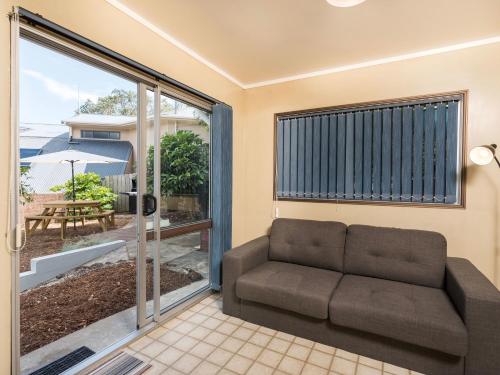a living room with a couch and a sliding glass door at Central Spacious Family House - Paihia House in Paihia