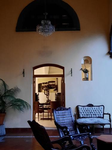 a room with two chairs and a mirror at Casa aroma de café, en el corazón de Coatepec. in Coatepec