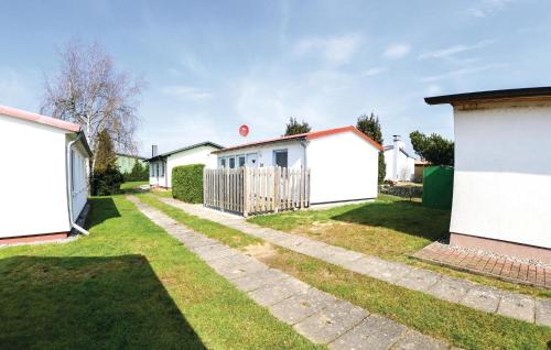 a yard with white houses and a fence at Holiday Home Zum Anleger I in Hohen Wieschendorf