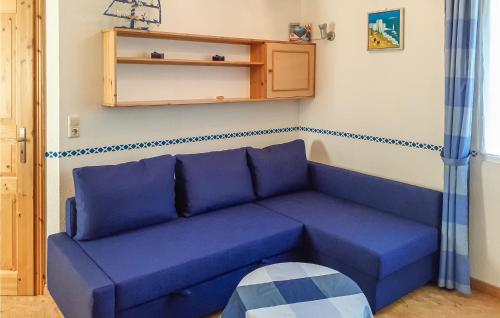 eine blaue Couch im Wohnzimmer in der Unterkunft Ferienhaus M�lschower Weg X in Trassenheide