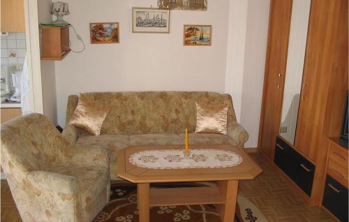 a living room with a couch and a candle on a table at Awesome Apartment In Karlshagen With Kitchenette in Karlshagen