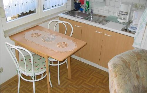 a small kitchen with a table and two chairs at Awesome Apartment In Karlshagen With Kitchenette in Karlshagen