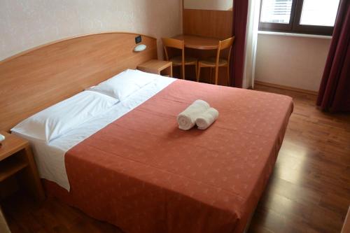 una camera d'albergo con un letto e due asciugamani di Hotel Nuovo a Milano