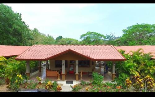 a small house with a red roof and some plants at Hotel D'Lucia - Quebrada Ganado, Jaco, Costa Rica in Puntarenas