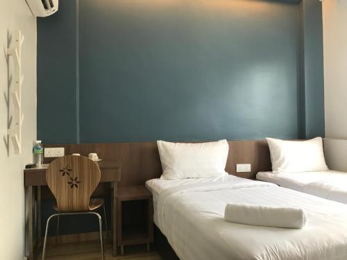 a bedroom with two beds and a desk and a chair at Festival Boutique Hotel - Damai Complex in Kuala Lumpur