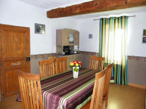 une cuisine avec une table avec un vase de fleurs dessus dans l'établissement Gîte Les Mimosas, à Prugnanes