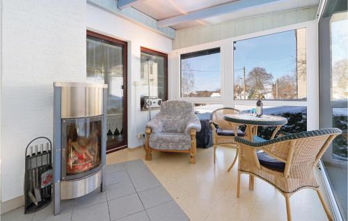 a living room with a fireplace and a table and chairs at Stunning Home In Auerbachot Rempesgrün in Auerbach
