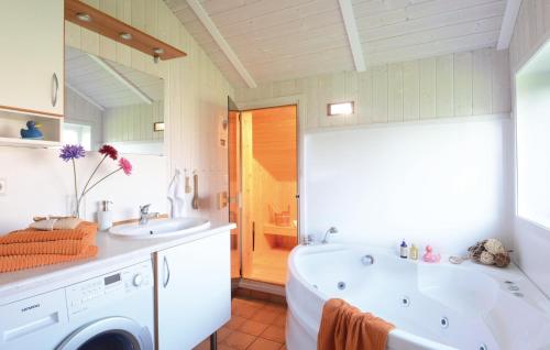 ein Badezimmer mit einer Badewanne und einer Waschmaschine in der Unterkunft Strandblick 33 in Schönhagen