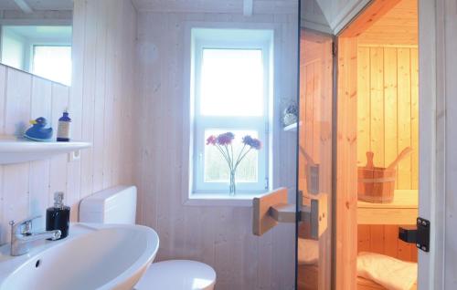 a bathroom with a sink and a toilet and a window at Strandblick 22 in Schönhagen