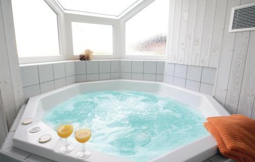 eine Badewanne mit zwei Gläsern Wein darin in der Unterkunft Strandblick 27 in Schönhagen