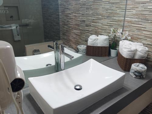 a white sink sitting in a bathroom next to a bath tub at Hotel Cortez in Ensenada