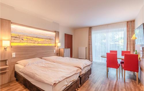 Schlafzimmer mit einem Bett, einem Tisch und Stühlen in der Unterkunft Hotel Wittensee in Groß Wittensee
