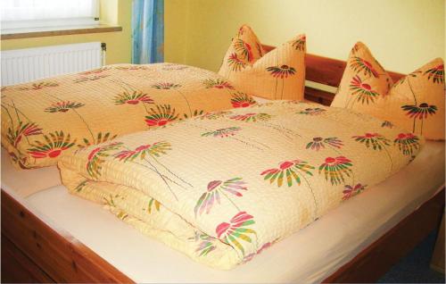 ホーヴァハトにあるStunning Apartment In Hohwacht With Kitchenetteのベッド(花の掛け布団付)