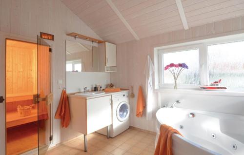 ein Badezimmer mit einer Waschmaschine und einem Waschbecken in der Unterkunft Strandblick 4 - Dorf 1 in Travemünde