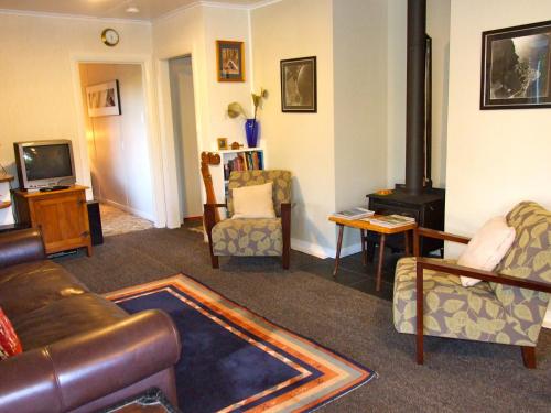 a living room with a couch and chairs and a television at Kuratau - Kuratau Bach in Kuratau