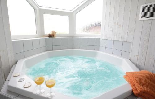 a bath tub with two glasses of wine in it at Strandblick 5 - Dorf 1 in Travemünde