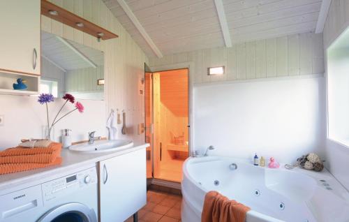 a white bathroom with a tub and a sink at Strandblick 14 - Dorf 1 in Travemünde