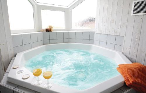 a bath tub with two glasses of wine in it at Dnenpark 15 - Dorf 6 in Travemünde