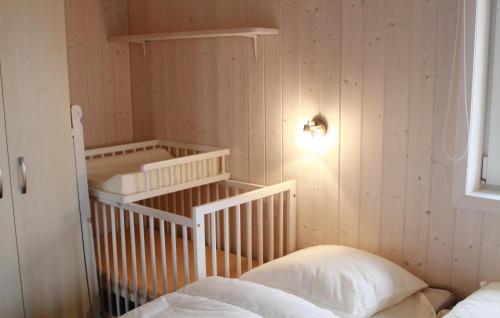 ein Schlafzimmer mit einem Kinderbett mit einer Lampe an der Wand in der Unterkunft Freibeuterweg 9 - Dorf 5 in Travemünde