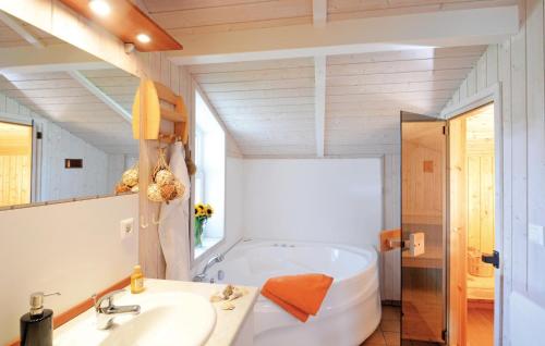 ein Badezimmer mit einer Badewanne und einem Waschbecken in der Unterkunft Friedrichskoog-strandpark 20 in Friedrichskoog