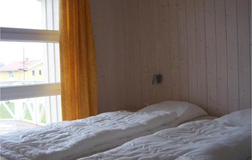 ein unmaskiertes Bett in einem Zimmer mit Fenster in der Unterkunft Friedrichskoog-strandpark 20 in Friedrichskoog