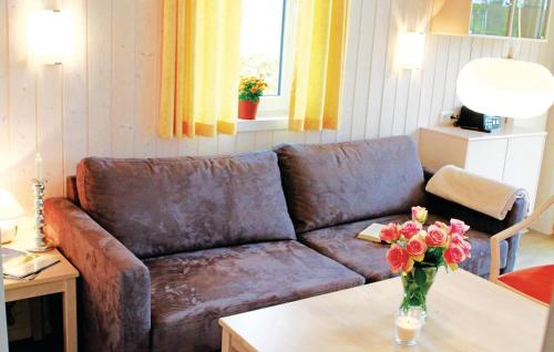 a living room with a couch and a table with flowers at Friedrichskoog-Deichblick 7 in Friedrichskoog