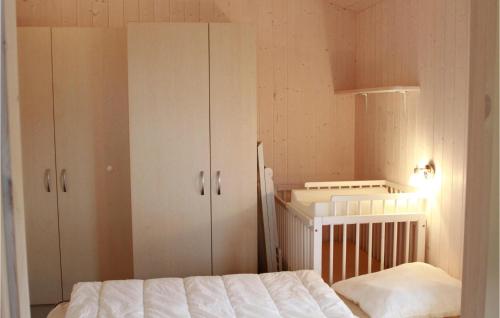 フリードリッヒシュコオクにあるFriedrichskoog-deichblick 8のベッドルーム1室(ベッド1台、キャビネット、ベビーベッド1台付)