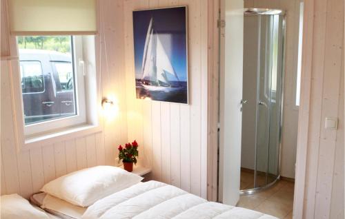 ein Schlafzimmer mit einem Bett und einem Bild eines Segelboots in der Unterkunft Friedrichskoog-deichblick 2 in Friedrichskoog