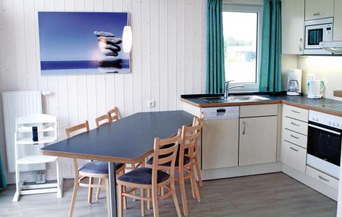 a kitchen with a table and chairs and a sink at Friedrichskoog-Deichblick 10 in Friedrichskoog