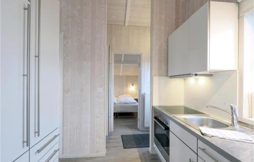 フリードリッヒシュコオクにあるFriedrichskoog-strandpark 1のキッチン(白いキャビネット、シンク付)、ベッドルーム1室が備わります。