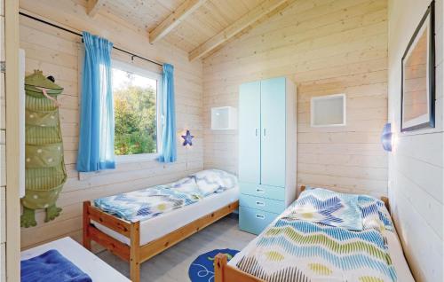 ein kleines Schlafzimmer mit 2 Betten und einem Fenster in der Unterkunft Ferienhaus Haustyp R in Süssau