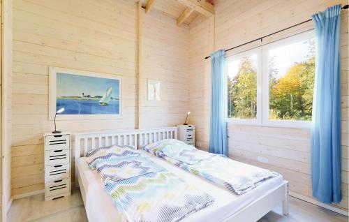 Schlafzimmer mit einem Bett und einem Fenster in der Unterkunft Ferienhaus Haustyp T in Süssau