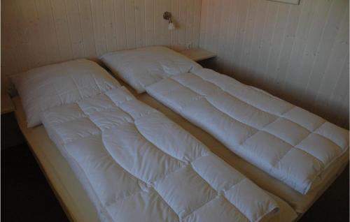 Bett in einem Zimmer mit zwei weißen Kissen in der Unterkunft Friedrichskoog-strandpark 14 in Friedrichskoog