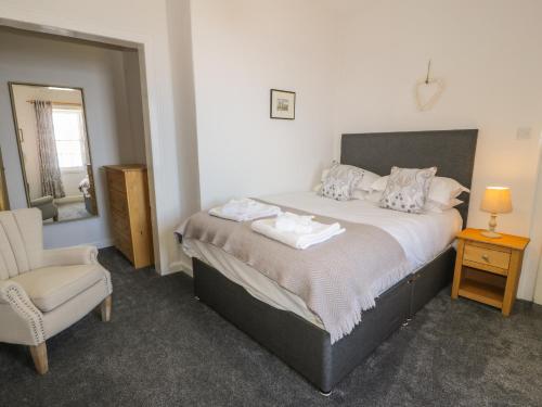 a bedroom with a large bed and a chair at South Segganwell - Culzean Castle in Maybole