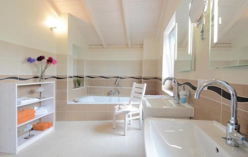 ein Badezimmer mit einer Badewanne und einem Waschbecken in der Unterkunft Ferienhaus K�stenweg G in Dagebüll