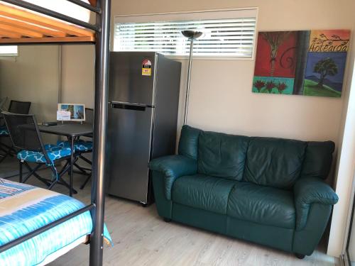 a living room with a couch and a table at Beach Pod Studio - Tairua Bach in Tairua