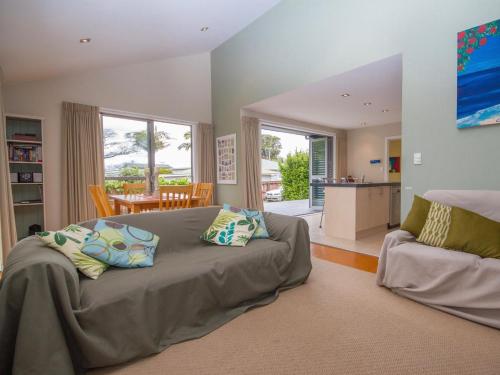 a living room with a bed and a dining room at Waihi Wonder - Waihi Holiday Home in Waihi Beach