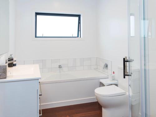 ein Badezimmer mit Badewanne, Toilette und Waschbecken in der Unterkunft Poolside Retreat - Picton Holiday House Waikawa in Picton