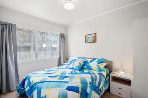 a white bedroom with a bed and a window at Central Stay - Taupo Flat in Taupo