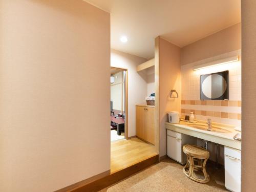 a bathroom with a sink and a mirror at Tabist Hotel Iyashi no Sato in Tsuchiura
