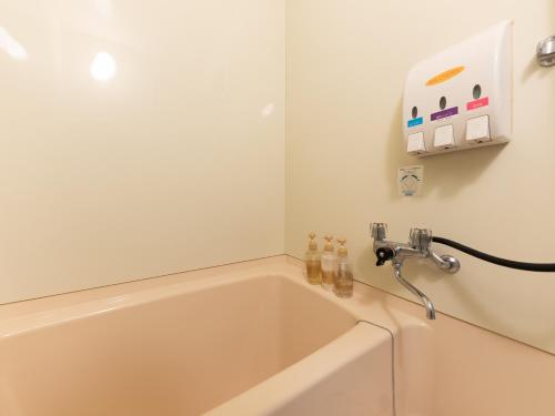 a bath tub with a faucet in a bathroom at Tabist Hotel Iyashi no Sato in Tsuchiura