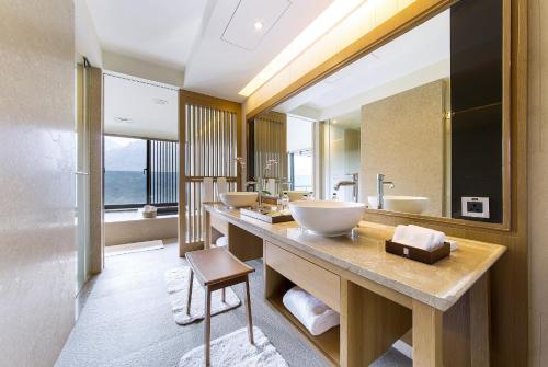 baño con 3 lavabos y espejo grande en Grand View Resort Beitou en Taipéi