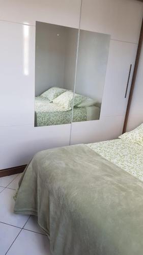 a bedroom with a mirror and a bed in it at QUARTO TOP no CENTR0 com Cama Box de casal - acomoda até 2 pessoas - Home Office - WIFI - Smart TV com Apps Youtube - Cozinha - banheiro - Sala de Estar - Apto compartilhado com Anfitriões experientes em hospedar - Superhost no BnB 5 estrelas in Criciúma