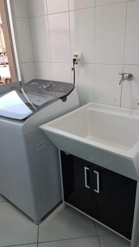 a white bathroom with a sink and a toilet at QUARTO TOP no CENTR0 com Cama Box de casal - acomoda até 2 pessoas - Home Office - WIFI - Smart TV com Apps Youtube - Cozinha - banheiro - Sala de Estar - Apto compartilhado com Anfitriões experientes em hospedar - Superhost no BnB 5 estrelas in Criciúma