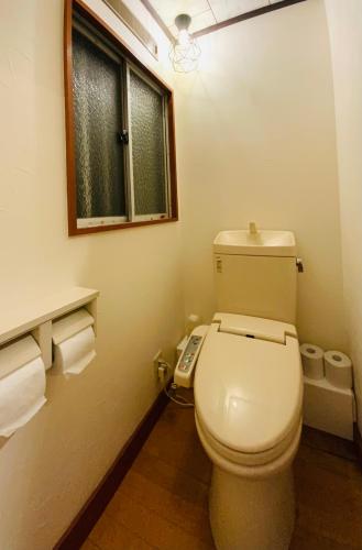a bathroom with a toilet with a window and towels at 森の宿り 那須別邸まるやま in Nasu