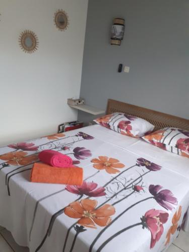 un dormitorio con una cama con un estampado de flores. en Ambiance sud sauvage en Saint-Joseph